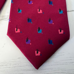 Maroon tie with geometric pattern on a light wooden surface