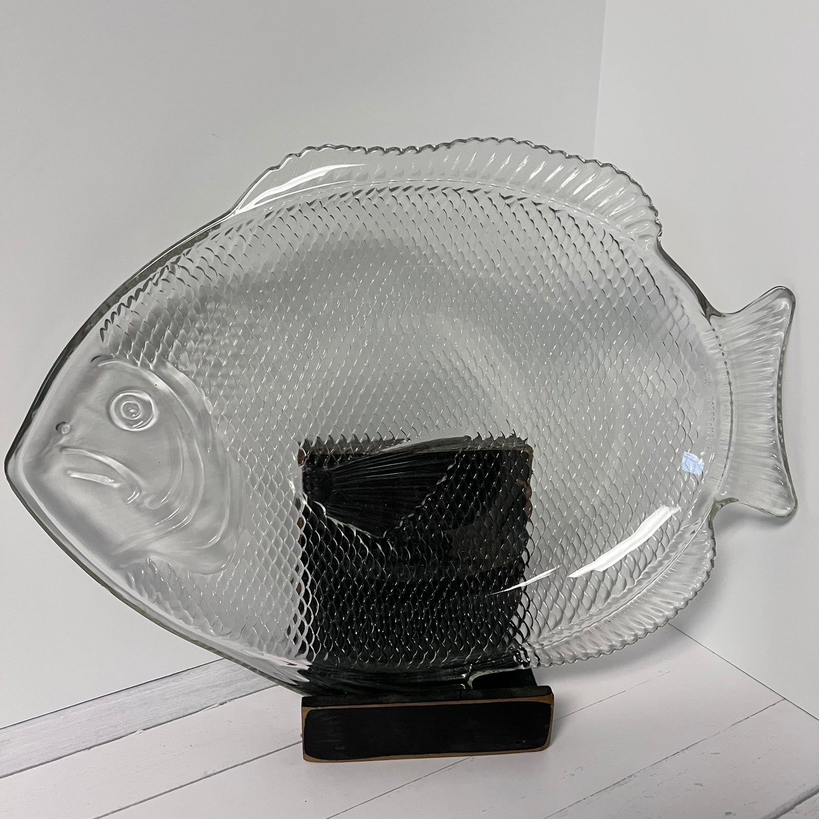 Clear glass fish-shaped platter on a white surface