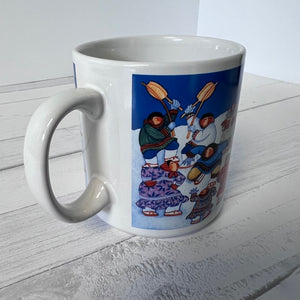 White mug with a colorful design of people and animals on a white surface