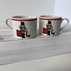 Two mugs with decorative designs on a white surface