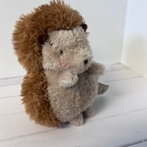 Plush toy hedgehog on a white wooden floor