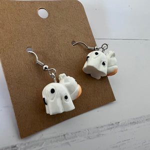 Pair of ghost-shaped earrings on a brown card with a white background