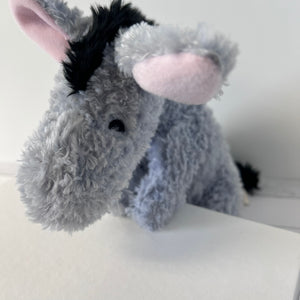 Plush donkey toy on a white surface with a neutral background