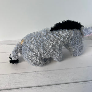 Plush toy resembling a donkey on a white wooden surface