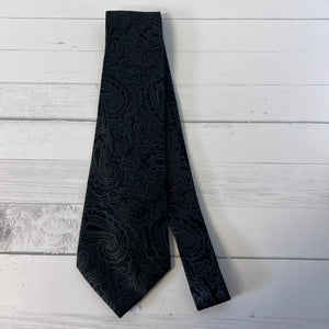 Black patterned tie on a light wooden surface