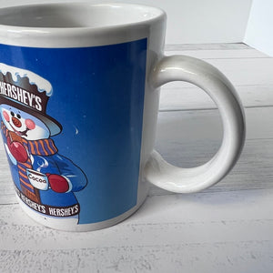 White mug with Hershey's chocolate-themed design on a white wooden surface
