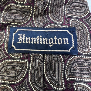 Fabric with a paisley pattern and a embroidered patch reading 'Huntington'.