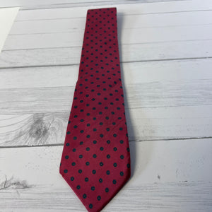 Red tie with black polka dots on a light wooden surface