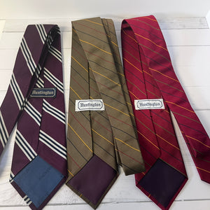 Three striped ties with 'Huntington' branding on a wooden surface