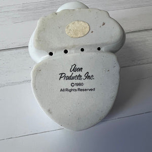Vintage ceramic product with 'Avon Products, Inc.' branding on a wooden surface