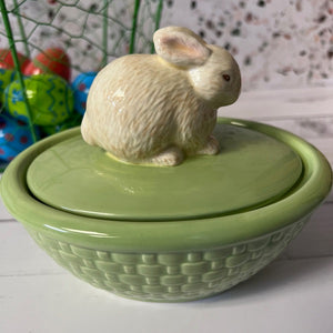Green ceramic bowl with a rabbit-shaped lid on a white surface.