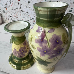 Ceramic vase and candle holder with floral design on a textured surface