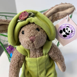 Plush toy rabbit in a green outfit with a flower on its head, branded 'Pacifica'.