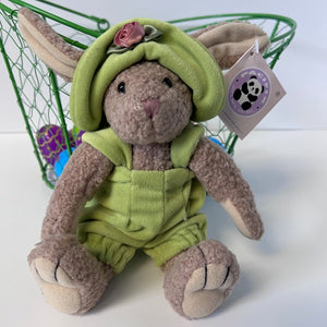Plush toy rabbit in green outfit with tag on a white background