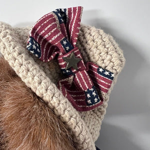 Beige knitted headband with American flag-themed bow on a neutral background