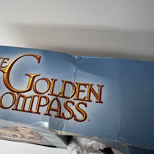 Close-up of 'The Golden Compass' logo on a blue background