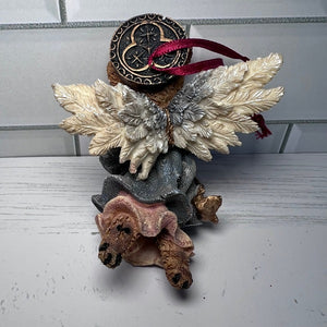 Decorative angel figurine with wings and a red ribbon on a white surface.