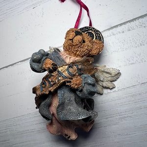 Decorative angel figurine with 'Peace' message on a white surface