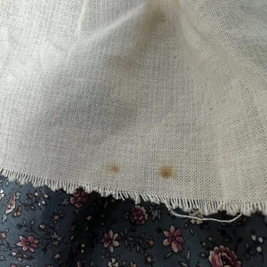 Close-up of a textured white fabric with a floral patterned surface underneath