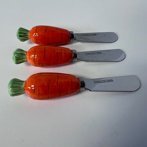 Three carrot-shaped knives with metal blades on a white background