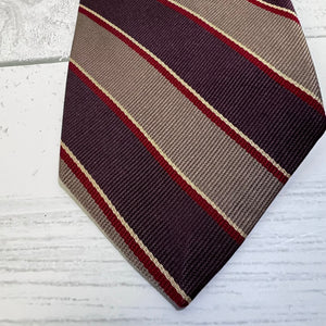 Striped tie with diagonal pattern on a light wooden surface