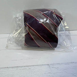 Striped tie in a clear plastic bag on a white wooden surface