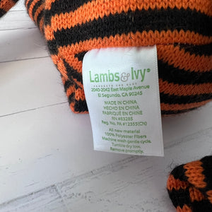 Lambs & Ivy label on a knitted item with orange and black stripes.