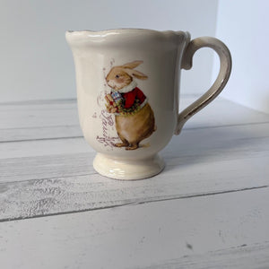 White ceramic mug with a rabbit illustration on a wooden surface