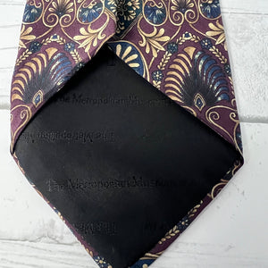 Black fabric with 'The Metropolitan Museum of Art' branding and a patterned purple tie on a white background