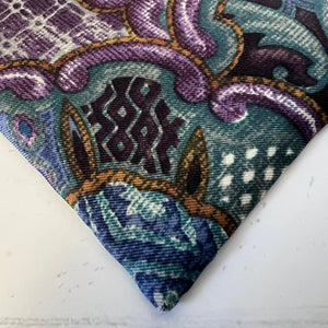Close-up of a patterned fabric with intricate designs on a white background