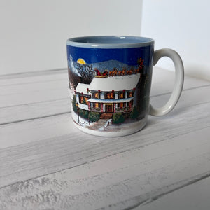 Mug with winter scene design on a white wooden surface