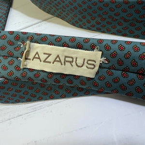 Folded patterned tie with 'LAZARUS' label on a white surface