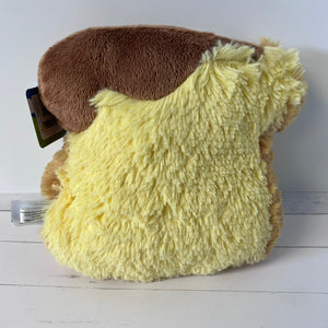 Plush toy resembling a character with a brown top and yellow bottom on a white surface.
