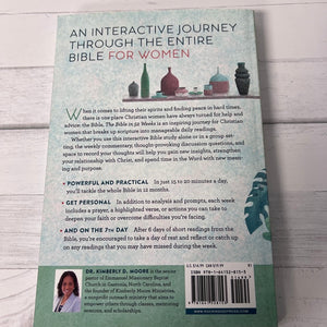 Back cover of a book titled 'An Interactive Journey Through the Entire Bible for Women' on a wooden surface.