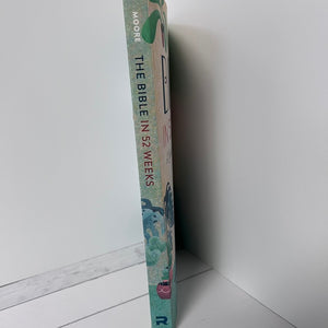 Book titled 'The Bible in 52 Weeks' by Moore on a white surface