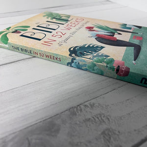 Book titled 'The Bible in 52 Weeks' on a wooden surface