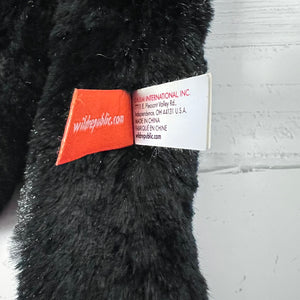Black plush toy with a visible brand label on a gray background