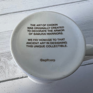 White mug with black text on a light wooden surface