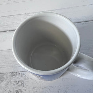 White ceramic mug on a light wooden surface