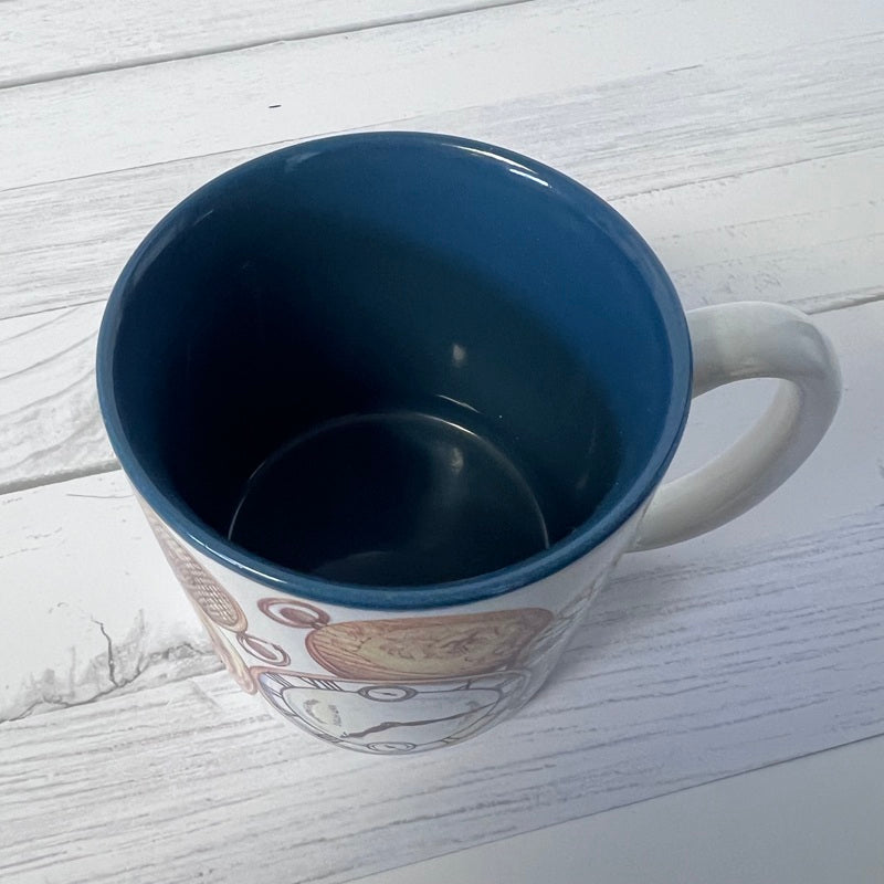 Blue mug with a white handle on a light wooden surface