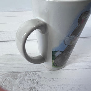 White mug with a rabbit design on a light wooden surface