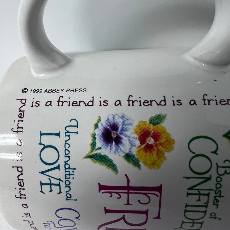 White mug with floral design and text about friendship and love on a white background