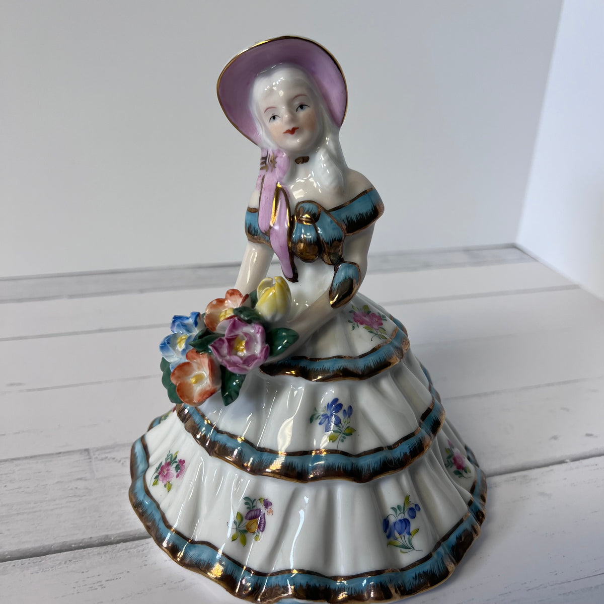 Porcelain Girl Figurine with Blue & Gold Accents – Holding Flowers