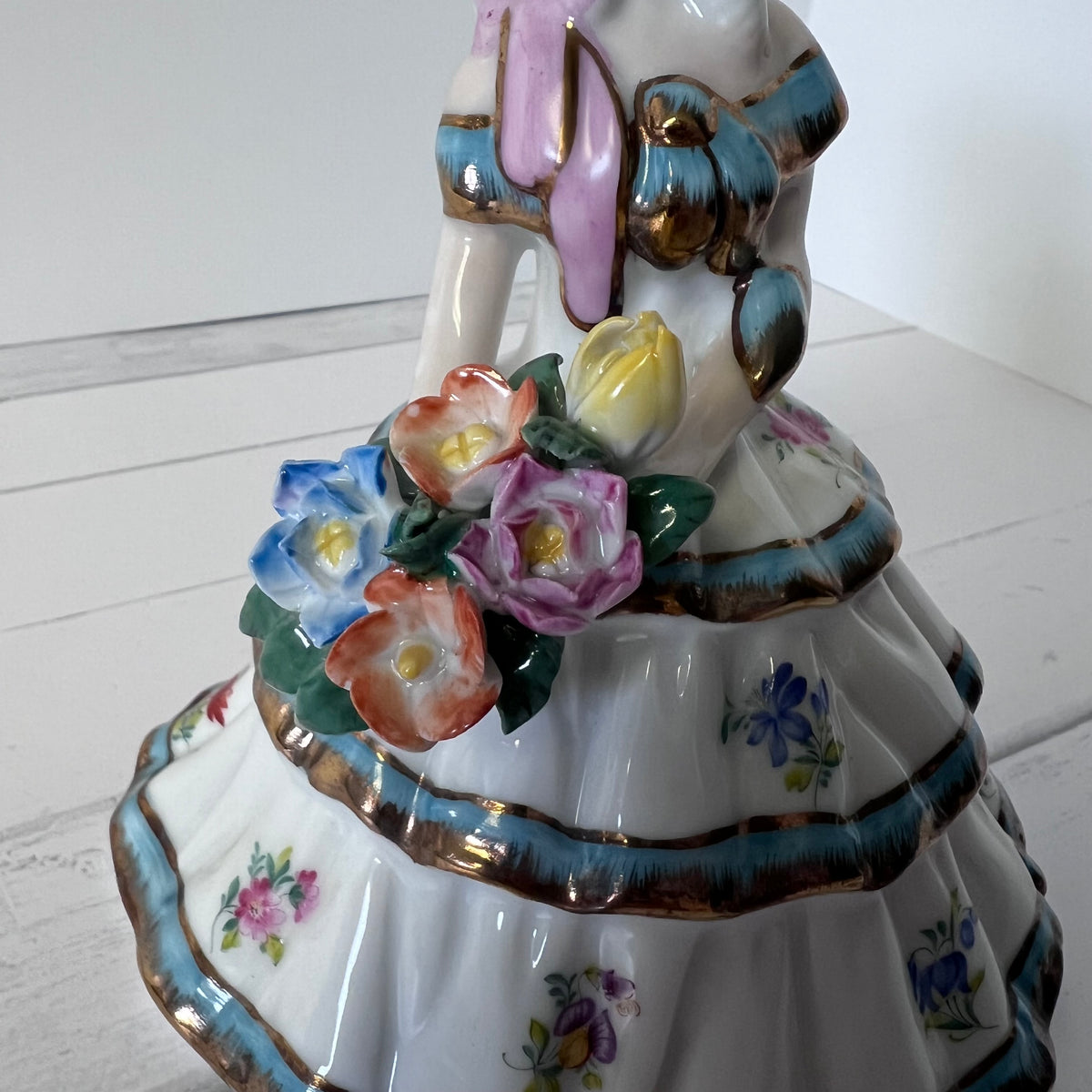 Porcelain Girl Figurine with Blue & Gold Accents – Holding Flowers