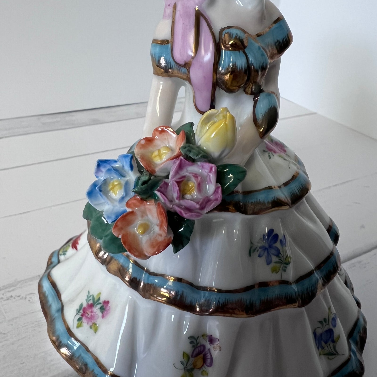 Porcelain Girl Figurine with Blue & Gold Accents – Holding Flowers