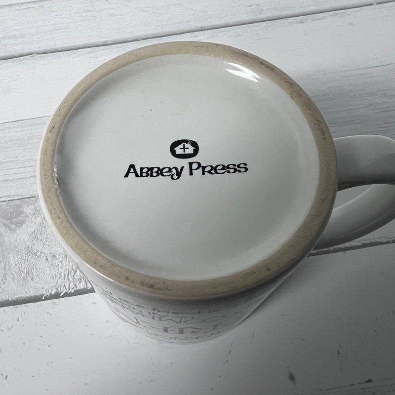 Mug with Abbey Press logo on a light wooden surface