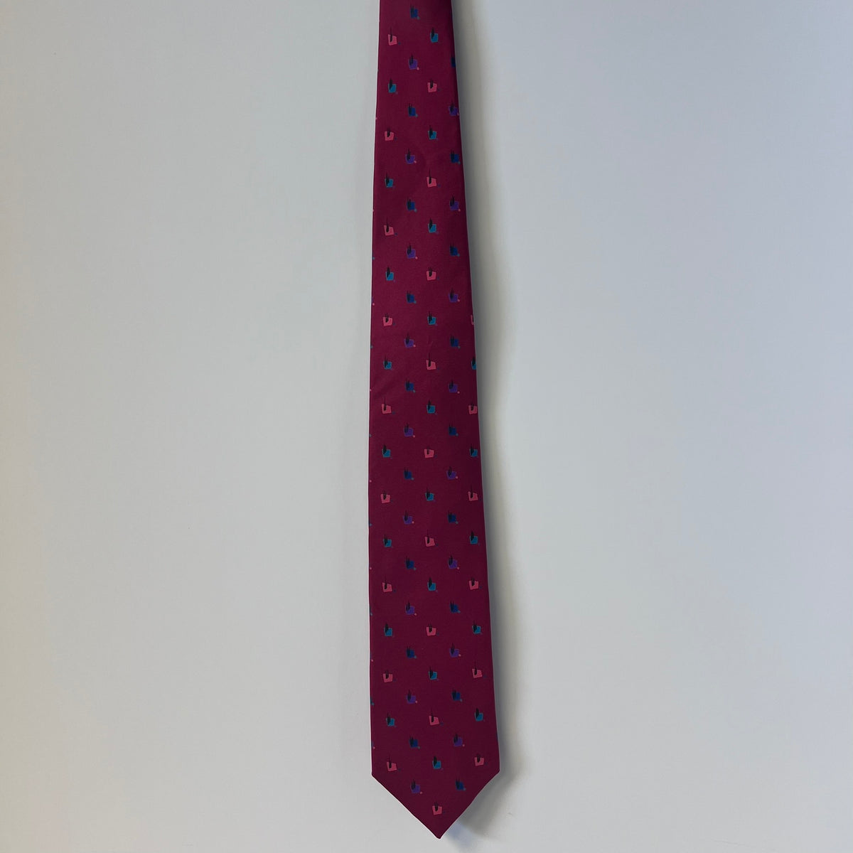 Maroon tie with small pattern on a light gray background