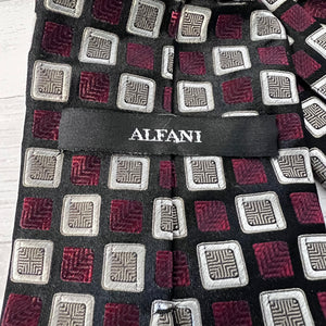 Patterned tie with geometric design and 'Alfani' label on a wooden surface