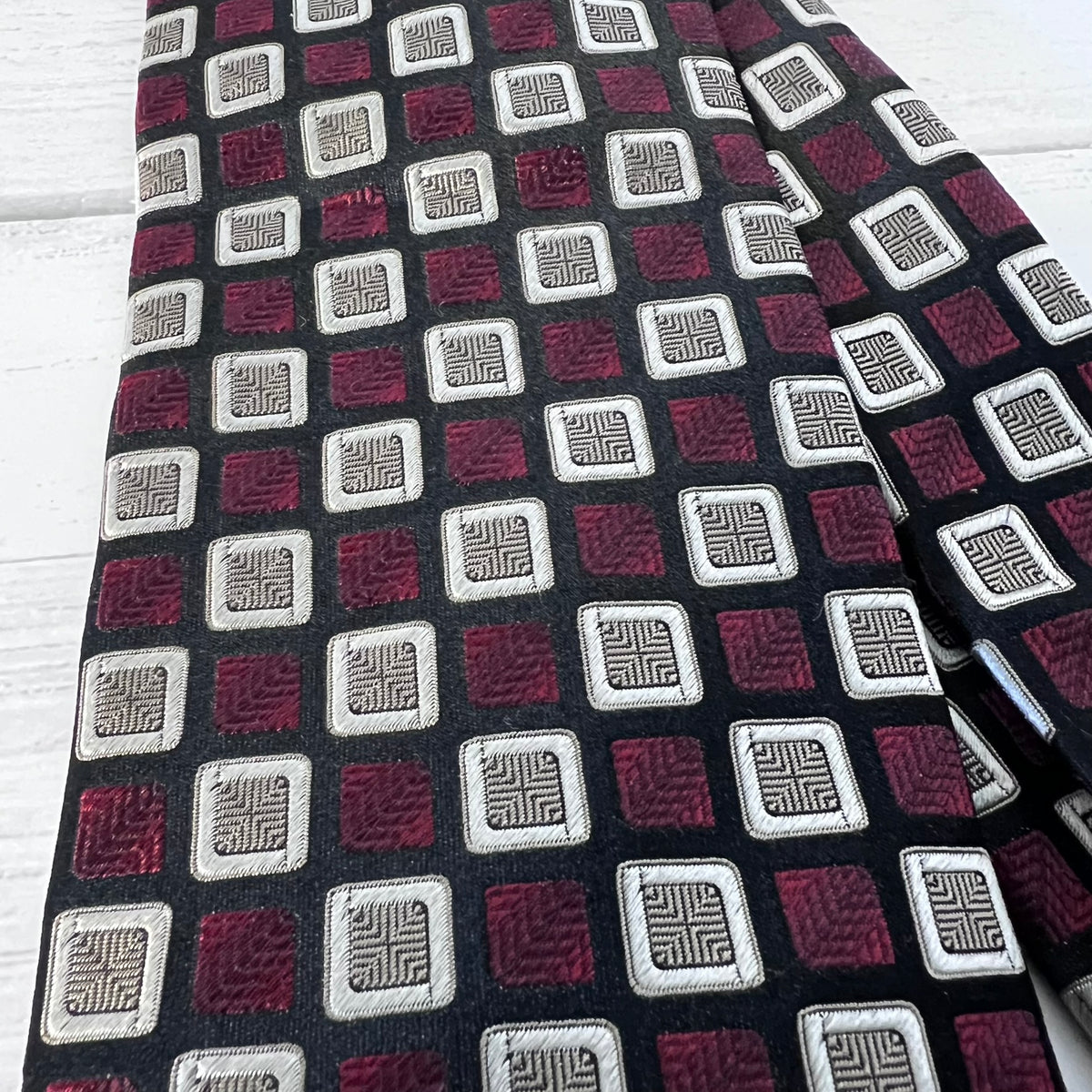 Patterned tie with geometric design on a wooden surface