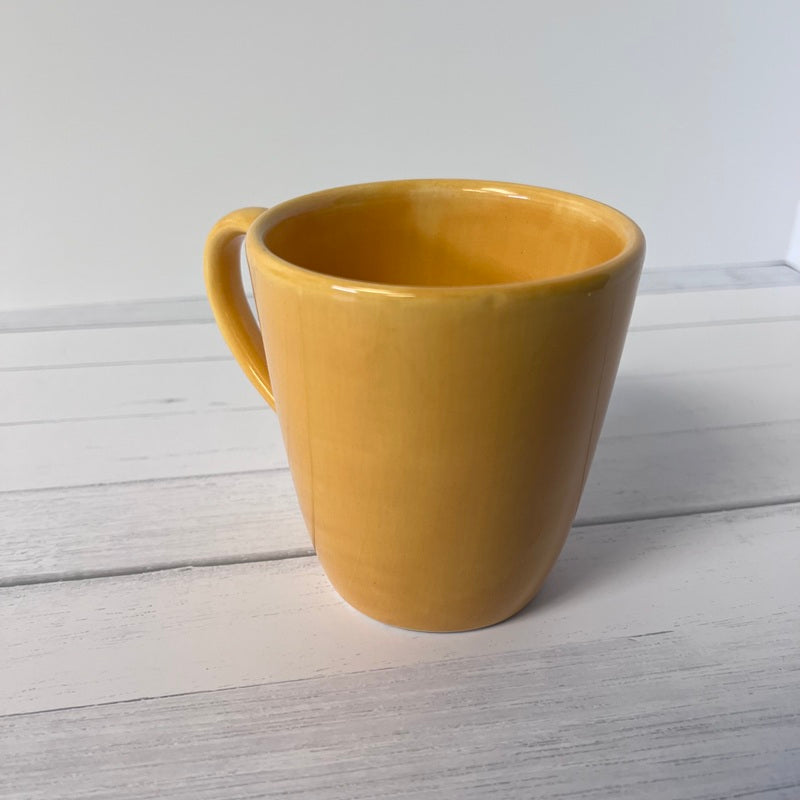 Yellow mug on a light wooden surface